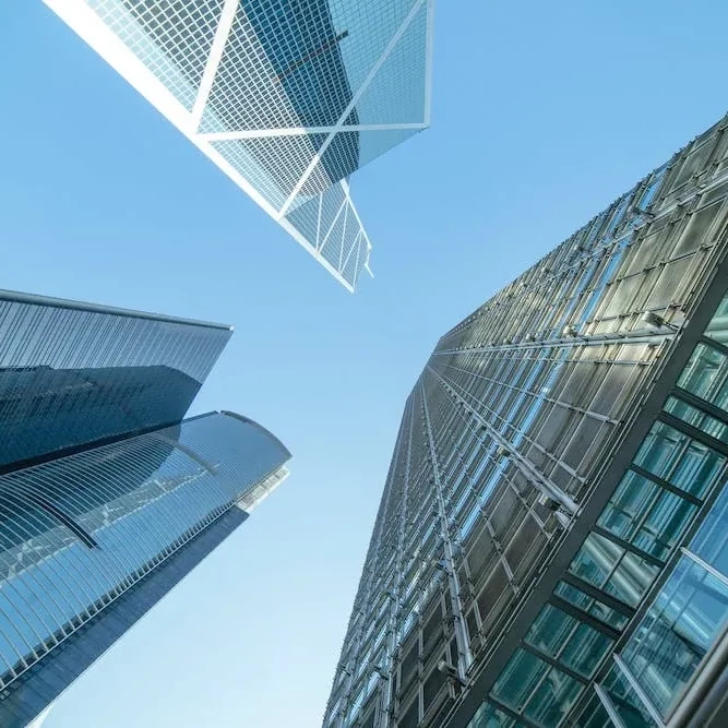 Low angle view of modern glass skyscrapers against a clear blue sky